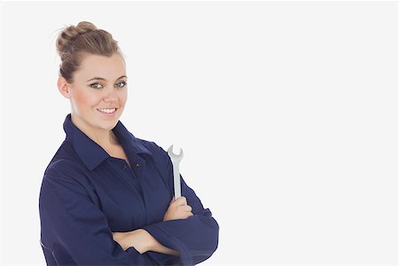 Portrait of young female technician holding wrench against white background Stock Photo - Budget Royalty-Free & Subscription, Code: 400-06868882