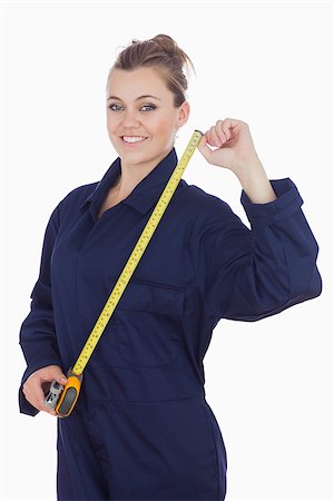 Portrait of young female mechanic with measuring tape standing against white background Stock Photo - Budget Royalty-Free & Subscription, Code: 400-06868893