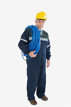 Full length portrait of mature repairman with large wire and hardhat against white background Photographie de stock - Aubaine LD & Abonnement, Code: 400-06868923