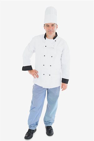 Full length portrait of mature chef in uniform standing with hand on waist against white background Stock Photo - Budget Royalty-Free & Subscription, Code: 400-06868970
