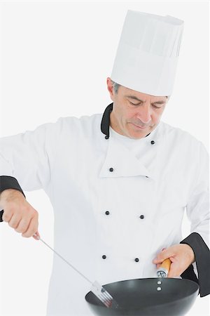 Male chef using spatula and frying pan over white background Stock Photo - Budget Royalty-Free & Subscription, Code: 400-06869075