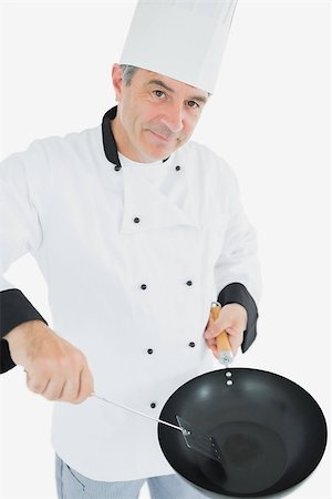 simsearch:400-07953213,k - Portrait of mature chef with spatula and frying pan over white background Foto de stock - Super Valor sin royalties y Suscripción, Código: 400-06869079