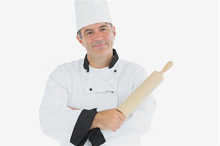 rolling over - Portrait of mature chef holding rolling pin over white background Photographie de stock - Aubaine LD & Abonnement, Code: 400-06869084