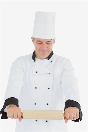 rolling over - Mature man in chef uniform using rolling pin over white background Photographie de stock - Aubaine LD & Abonnement, Code: 400-06869087