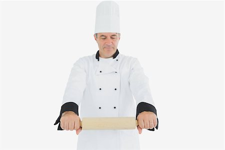 rolling over - Male mature chef holding rolling pin over white background Photographie de stock - Aubaine LD & Abonnement, Code: 400-06869089