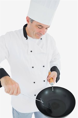 simsearch:400-07953213,k - Male mature chef cooking food using spatula and frying pan over white background Foto de stock - Super Valor sin royalties y Suscripción, Código: 400-06869080