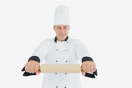 rolling over - Male chef in uniform holding rolling pin over white background Photographie de stock - Aubaine LD & Abonnement, Code: 400-06869091