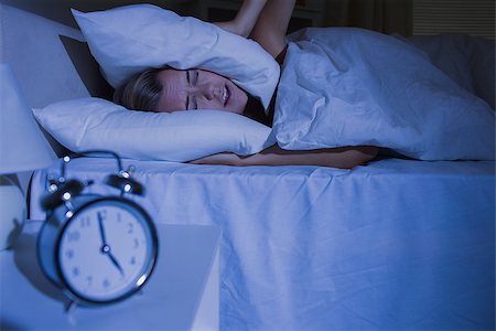 Blond woman putting pillows on her ears at night Stock Photo - Budget Royalty-Free & Subscription, Code: 400-06869256