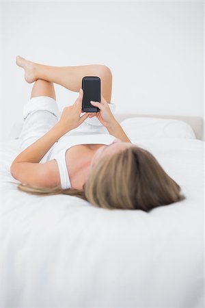 rear view of woman texting cellphone - Quiet woman looking at her phone on the bed Stock Photo - Budget Royalty-Free & Subscription, Code: 400-06869283