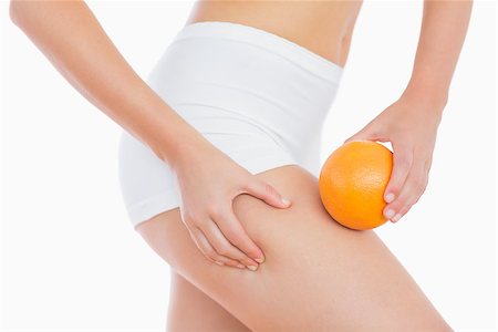 pictures of fat orange women - Midsection of woman squeezing fat on thigh as she holds orange over white background Stock Photo - Budget Royalty-Free & Subscription, Code: 400-06869736