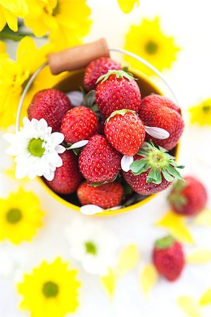 simsearch:400-08672192,k - Fresh strawberries  in yellow bucket on the white background with yellow flowers Photographie de stock - Aubaine LD & Abonnement, Code: 400-06860088