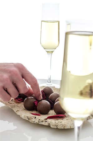 setting table hands - Man eating chocolate candy decorated with leaves on a plate made of stone. Stock Photo - Budget Royalty-Free & Subscription, Code: 400-06860370