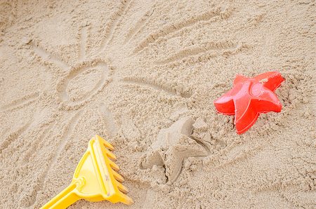 simsearch:400-09237669,k - Sun drawn in sand on a sandy beach. With summer toys. Stock Photo - Budget Royalty-Free & Subscription, Code: 400-06860384