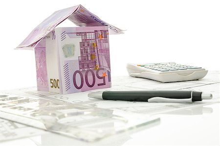 House made of Euro money on a working desk with ruler, pen, calculator and blueprint. Stockbilder - Microstock & Abonnement, Bildnummer: 400-06860399