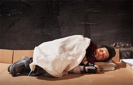 simsearch:400-06875322,k - Beggar boy sleeping on cardboard sheet in the dark - with copy space Fotografie stock - Microstock e Abbonamento, Codice: 400-06860455