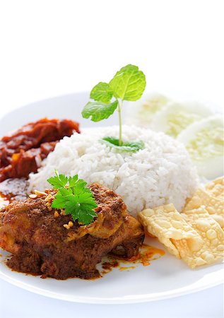 Nasi lemak kukus traditional malaysian spicy rice dish. Served with belacan, ikan bilis, acar, peanuts and cucumber. White background. Stock Photo - Budget Royalty-Free & Subscription, Code: 400-06860616