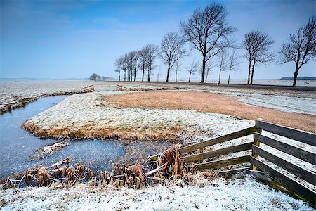 wooden fence and frozen canals in Dutch farmland Stockbilder - Microstock & Abonnement, Bildnummer: 400-06861102