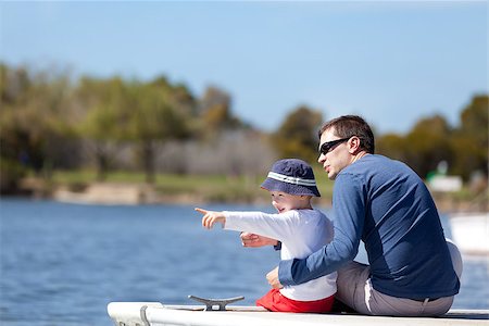 young father and his son sitting at the marina dock and spending fun time together; adorable little boy pointing with his finger and showing something to his father Stock Photo - Budget Royalty-Free & Subscription, Code: 400-06862192