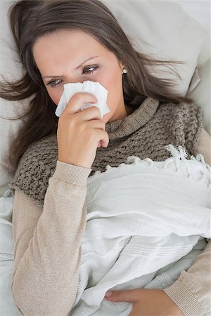 simsearch:400-06888942,k - Sick woman holding tissue to nose on the couch Photographie de stock - Aubaine LD & Abonnement, Code: 400-06862808