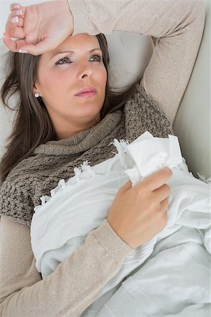 simsearch:400-06868935,k - Ill woman lying on sofa with blanket holding a tissue feeling sorry for herself Foto de stock - Super Valor sin royalties y Suscripción, Código: 400-06862810