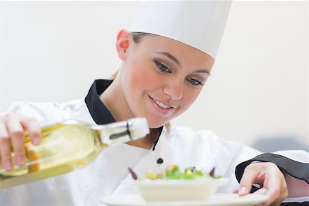 simsearch:400-06863053,k - Smiling chef pouring oil over salad Stockbilder - Microstock & Abonnement, Bildnummer: 400-06862981