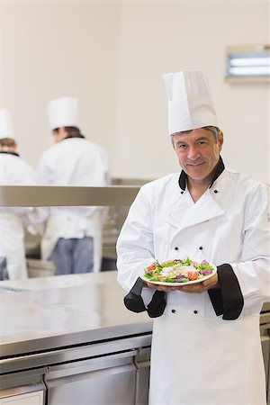 simsearch:400-06863053,k - Smiling chef showing his salad in the kitchen Stockbilder - Microstock & Abonnement, Bildnummer: 400-06862997