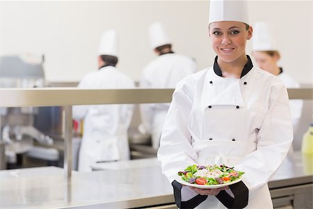 simsearch:400-06863053,k - Smiling chef showing her salad in the kitchen Stockbilder - Microstock & Abonnement, Bildnummer: 400-06863001