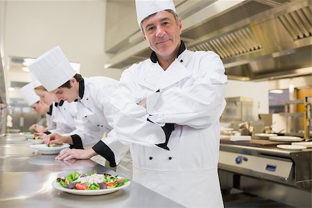 simsearch:400-06863053,k - Chef smiling with arms crossed with others preparing salad Stockbilder - Microstock & Abonnement, Bildnummer: 400-06863017