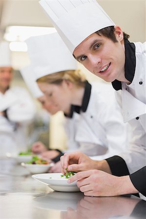 simsearch:400-06863053,k - Chef looking up from preparing salad in culinaryclass and smiling Stockbilder - Microstock & Abonnement, Bildnummer: 400-06863026