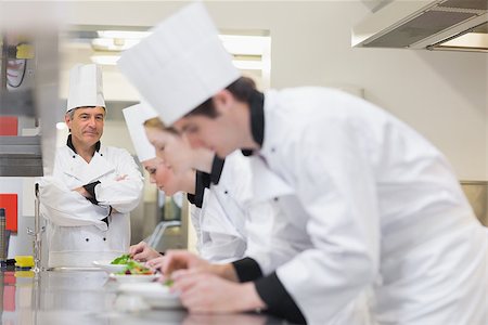 simsearch:400-06863053,k - Chef overlooking others preparing salads in kitchen Stockbilder - Microstock & Abonnement, Bildnummer: 400-06863021