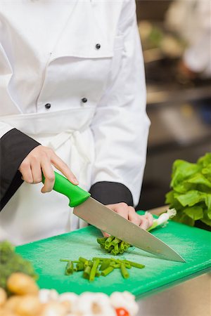 simsearch:649-08766085,k - Chef slicing up scallions on chopping board in kitchen Photographie de stock - Aubaine LD & Abonnement, Code: 400-06863118