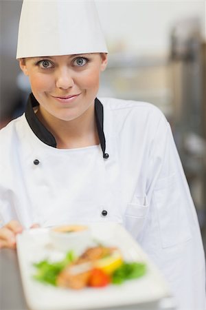 simsearch:400-06863053,k - Smiling chef behind dinner plate in the kitchen Stockbilder - Microstock & Abonnement, Bildnummer: 400-06863126