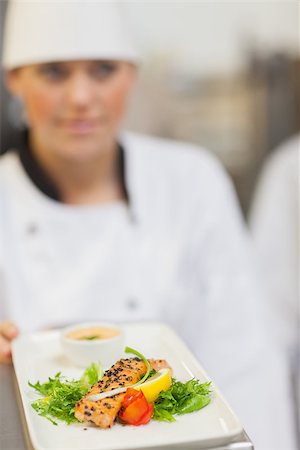 simsearch:400-06863053,k - Chef showing plate of salmon dinner in kitchen Stockbilder - Microstock & Abonnement, Bildnummer: 400-06863127
