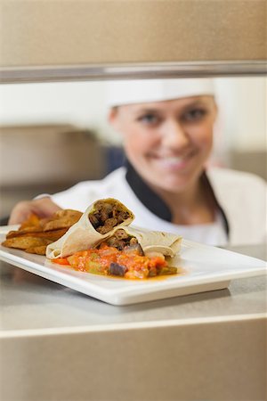 simsearch:400-06863053,k - Smiling chef giving plate for dinner in the restaurant through order station Stockbilder - Microstock & Abonnement, Bildnummer: 400-06863166