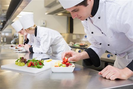 simsearch:400-06863053,k - Chef preparing a fruit salad in a busy kitchen Stockbilder - Microstock & Abonnement, Bildnummer: 400-06863162