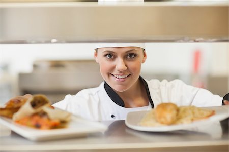 simsearch:400-06863053,k - Chef handing dinner plates through order station in the kitchen Stockbilder - Microstock & Abonnement, Bildnummer: 400-06863163