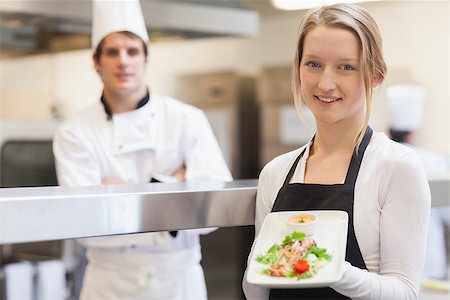 Smiling waitress carrying salmon plate in the kitchen Stock Photo - Budget Royalty-Free & Subscription, Code: 400-06863194