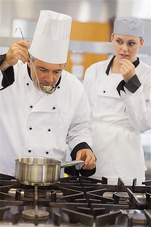 simsearch:6102-03828433,k - Teacher tasting his students soup with her watching anxiously in kitchen of culinary school Stockbilder - Microstock & Abonnement, Bildnummer: 400-06863282