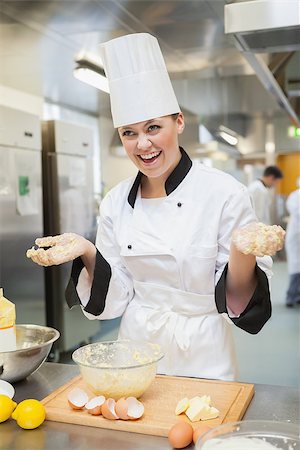 pastry chef uniform for women - Laughing baker showing hands covered in dough in the kitchen Stock Photo - Budget Royalty-Free & Subscription, Code: 400-06863290