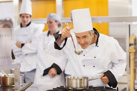 simsearch:6102-03828433,k - Smiling chef tasting his students work in kitchen Stockbilder - Microstock & Abonnement, Bildnummer: 400-06863293