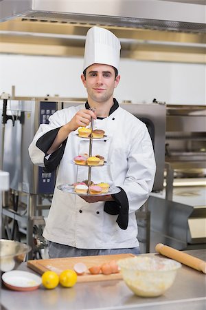 Pastry chef holding tiered cake tray in kitchen Stock Photo - Budget Royalty-Free & Subscription, Code: 400-06863309