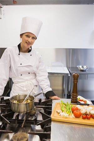 simsearch:6102-03828433,k - Woman smiling while standing at stove and cooking soup Stockbilder - Microstock & Abonnement, Bildnummer: 400-06863407