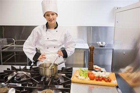 simsearch:6102-03828433,k - Chef standing at stove while smiling and cooking Stockbilder - Microstock & Abonnement, Bildnummer: 400-06863408