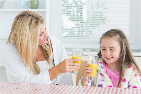 simsearch:400-04416091,k - Mother and child drinking juice at the kitchen Fotografie stock - Microstock e Abbonamento, Codice: 400-06863548