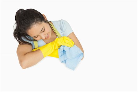 simsearch:400-06863562,k - Smiling woman in rubber gloves and apron looking at white surface holding rag Stockbilder - Microstock & Abonnement, Bildnummer: 400-06863656