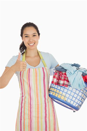 Laughing woman holding laundry basket full of dirty clothes showing thumbs up Stock Photo - Budget Royalty-Free & Subscription, Code: 400-06863715