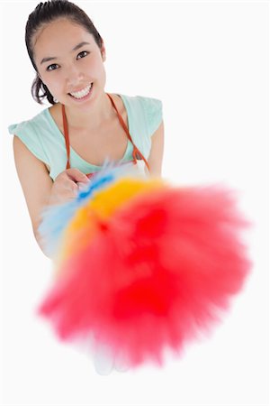 espanador de penas - Happy woman holding a duster in the air on a white background Foto de stock - Royalty-Free Super Valor e Assinatura, Número: 400-06863968