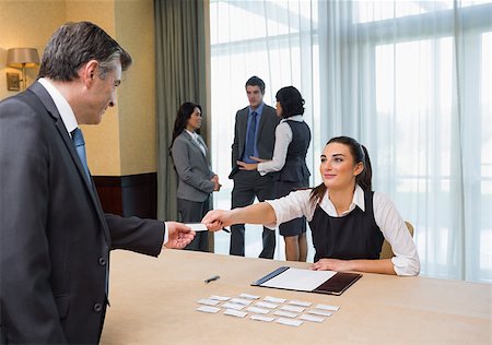 registration - Woman handing name tag to businessman at welcome desk at conference Stock Photo - Budget Royalty-Free & Subscription, Code: 400-06874006