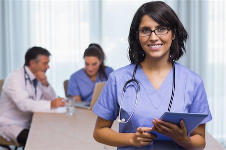Smiling nurse with tablet pc at a meeting Stock Photo - Budget Royalty-Free & Subscription, Code: 400-06874044