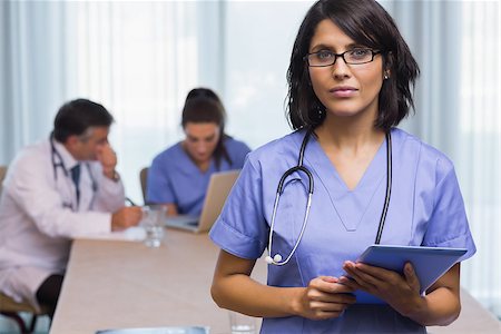 Nurse standing with tablet pc at a meeting Stock Photo - Budget Royalty-Free & Subscription, Code: 400-06874043